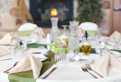 Place setting for a wedding with glasses, cloth napkins, silverware and party favors